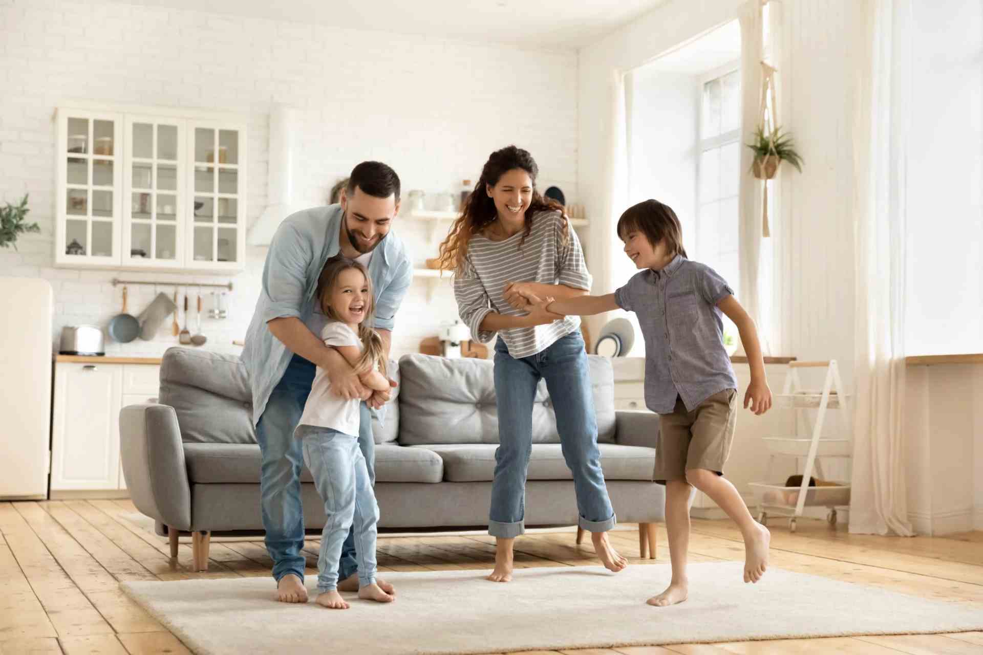 A family dancing in a living room after receiving conyeyancing services. 