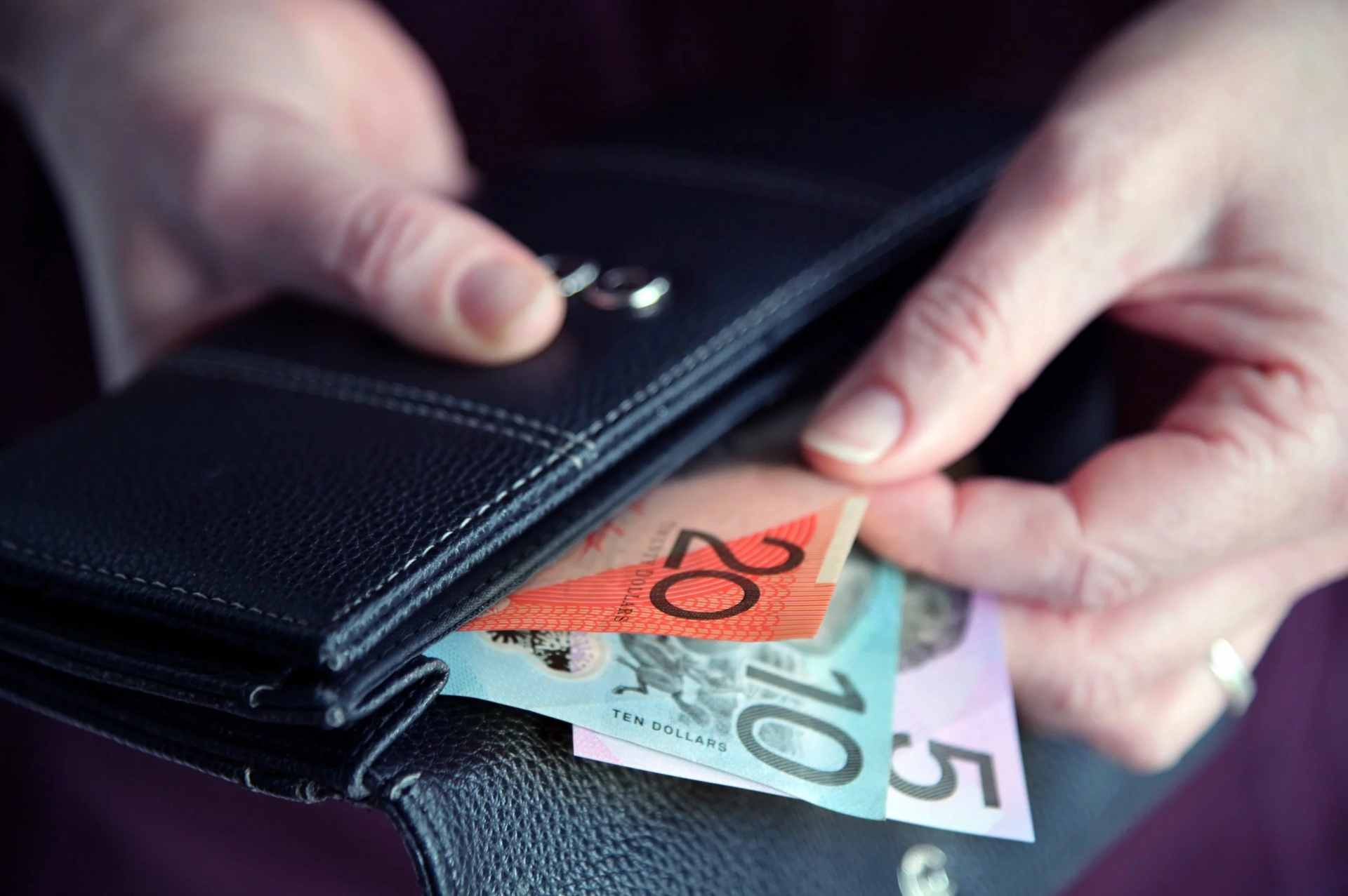 A black wallet with australian money preparing to pay a tax bill